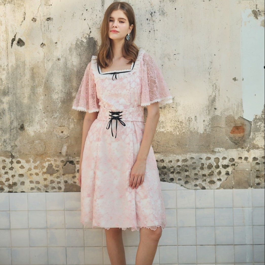 Tohns Flare Sleeve Corset Lace Dress, Light Pink Lace Dress, A-Line Shape. Butterfly Wing-Shaped Ruffled Sleeves Add Cuteness with a Ruffled Neckline and a Black Bow on the Body. Helps Create a Sweet, Elegant and Outstanding Look. ราคา 4,950 บาท*ส่งฟรี